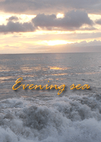 夕暮れどき波打ち際の茜色に染まる海です。