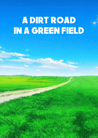 A dirt road in a green field
